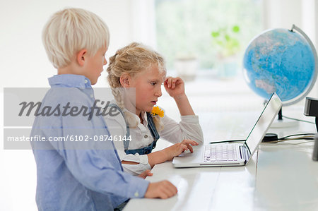 Girl and boy working on laptop