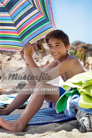 Smiling boy sitting on beach