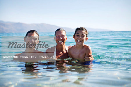 Mother with sons bathing in sea