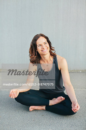 Smiling woman sitting in lotus position