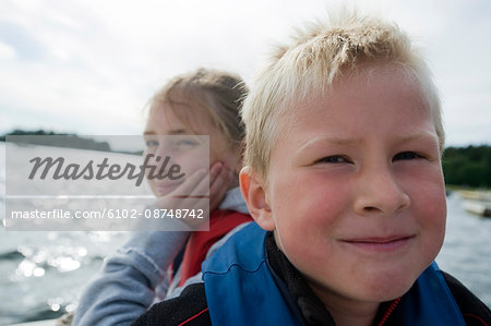 A boy and a girl sitting in a boat, Sweden.