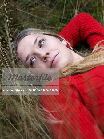 Portrait of young woman resting in grass
