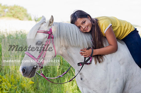 Portrait of girl sitting on horse