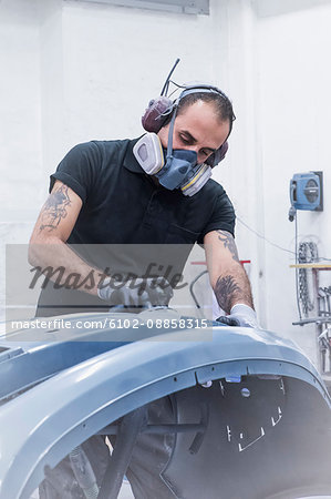 Man sanding car parts