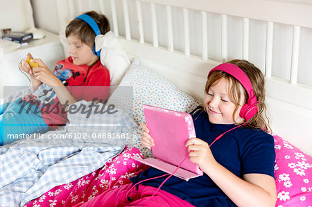 Brother and sister using wireless devices