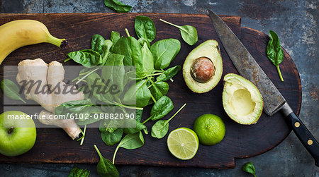 Avocado, spinach, ginger, apple and banana on cutting board