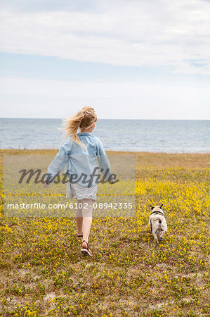 Girl walking with dog at sea Girl walking with dog at sea