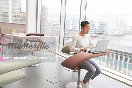 Young woman using laptop in library
