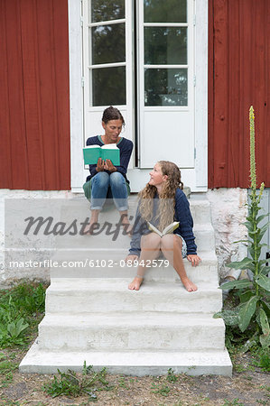 Mother with daughter reading on stairs