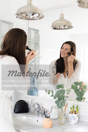Woman in bathroom doing make-up