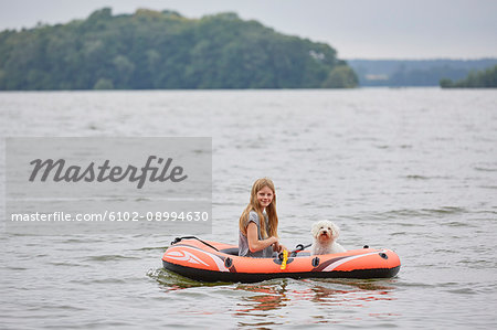 Girl with dog on inflatable boat