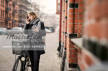 Young woman with bicycle on the phone