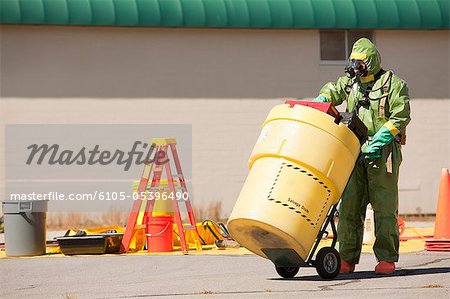 HazMat firefighter pushing a salvage drum