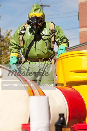 HazMat firefighter pushing a salvage drum