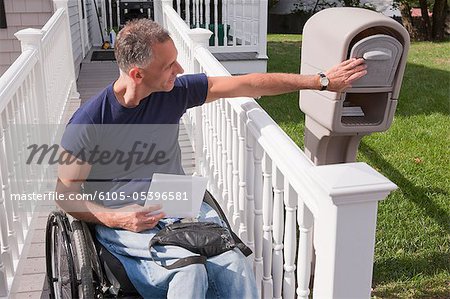 Man with spinal cord injury in a wheelchair getting his mails