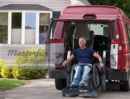 Man with spinal cord injury in a wheelchair getting in his accessible van