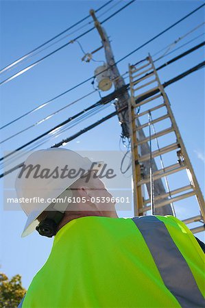 Engineer placing a ladder to climb power pole