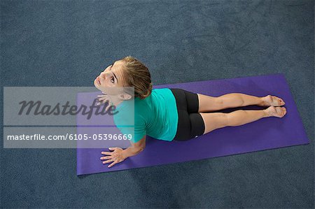 Woman doing cobra pose in a gym