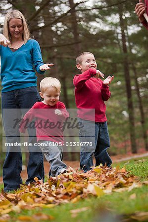 Woman signing the word 'Jump' in American Sign Language while communicating with her sons in a park