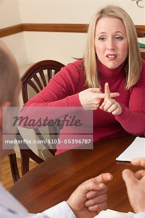 Woman signing the word 'Rent' in American Sign Language while communicating with a man