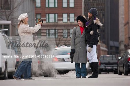 Woman taking picture of her mother and daughter, State Street, Boston, Massachusetts, USA