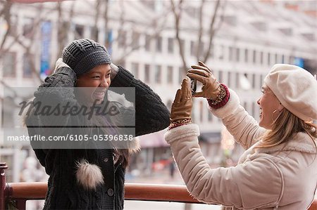 Woman taking picture of her daughter with a mobile phone, Boston, Massachusetts, USA