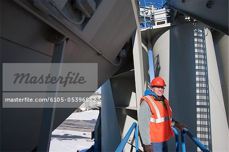 Engineer standing on inspection platform at materials plant