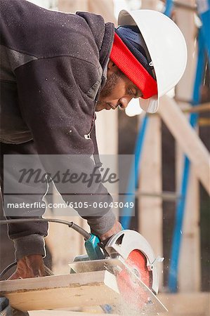 Carpenter using a circular saw for cutting rafter