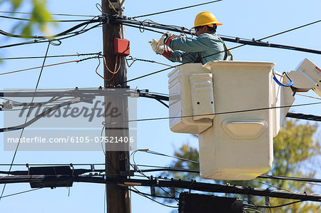 Power engineer in lift bucket working on power lines, Braintree, Massachusetts, USA