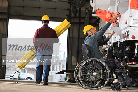 Maintenance supervisor in utility garage and loading new truck with supplies one man carrying hole shielding