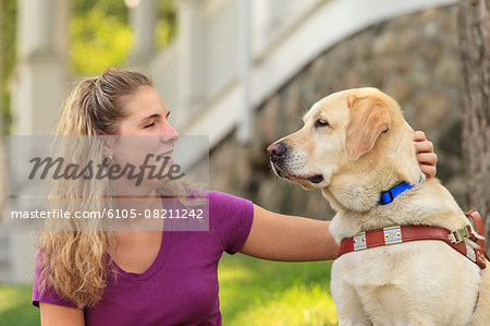 Woman with visual impairment petting her service dog
