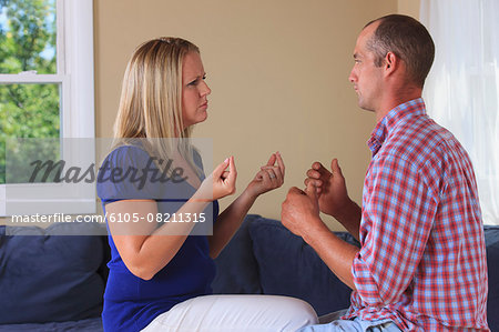 Husband and wife with hearing impairments signing 'what should we do' in American sign language