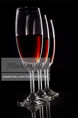 Close-up of three glasses of wine against black background