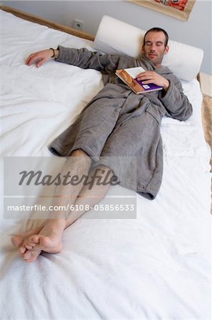 Man in grey bathrobe, sleeping in bed