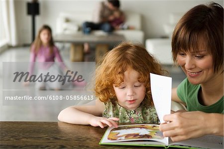 Woman and little girl reading a children's book