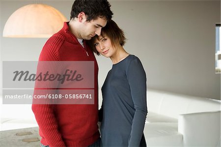 Couple standing face to face in a living-room