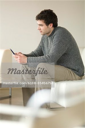 Man sitting on a sofa using a mobile phone