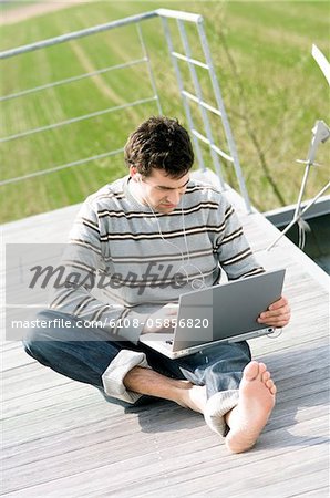 Man sitting on a terrace using laptop computer