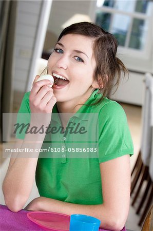 Young woman eating an hard-boiled egg