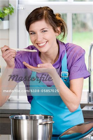 Young smiling woman tasting food