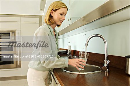Woman filling glass with tap water