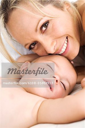 Portrait mother smiling and her baby sleeping, indoors