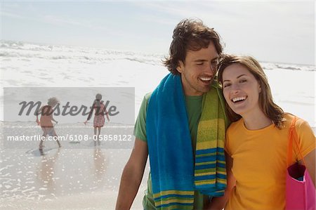 Parents and two children walking on the beach, outdoors