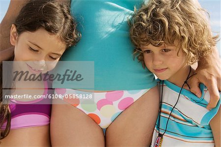Portrait of two children and their mother, wearing bathsuit, outdoors