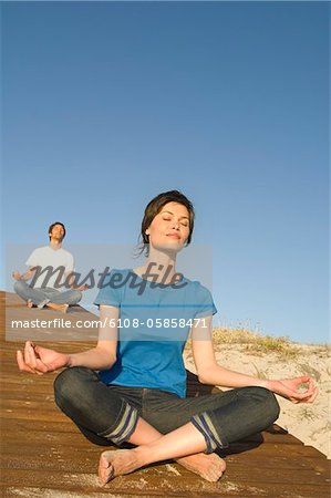 Young couple in yoga attitude, outdoors