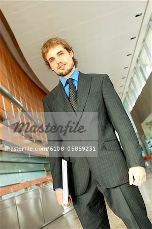 Businessman holding files, low angle view