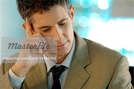 Mid adult businessman with hand on forehead