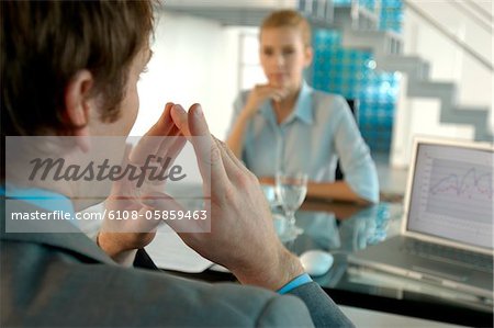 Businessman conversing with businesswoman in background