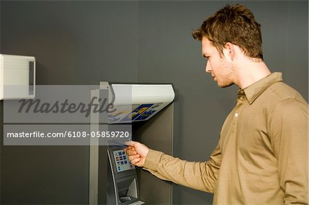 Young man using an ATM
