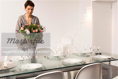 Mid adult woman setting a dining table